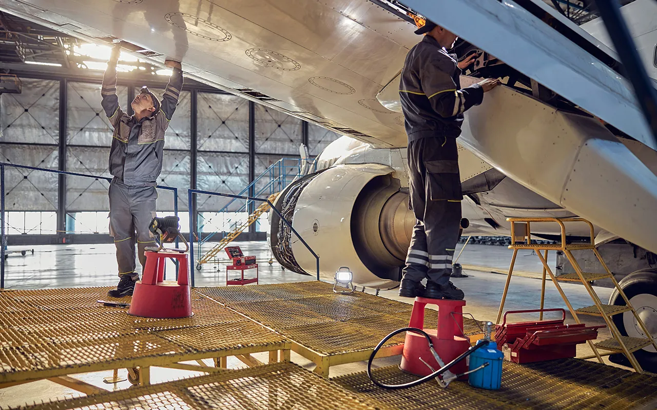 Workers working with tools on an airplane